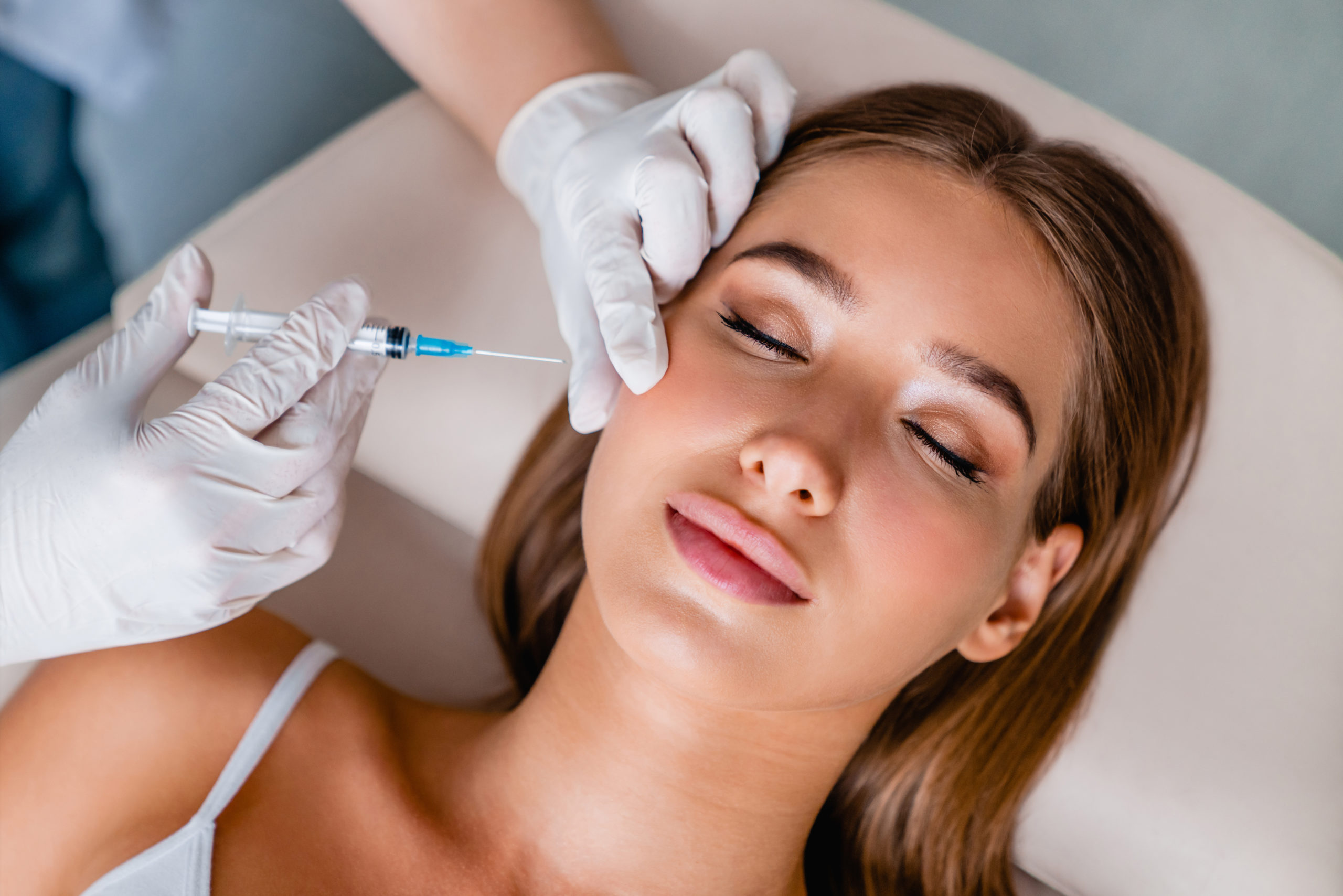 Doctor injecting botox on woman's face